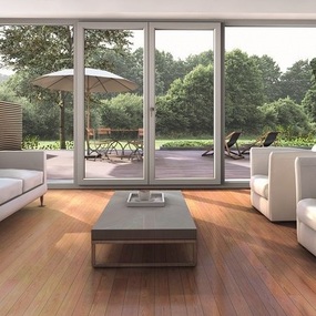 Modernes Wohnzimmer mit großen Glasfronten, Holzboden und Blick auf Terrasse mit Garten.