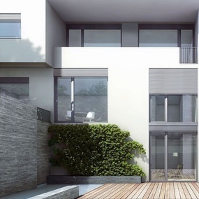 Modernes Einfamilienhaus mit großer Fensterfront, Terrasse und begrüntem Gartenbereich.